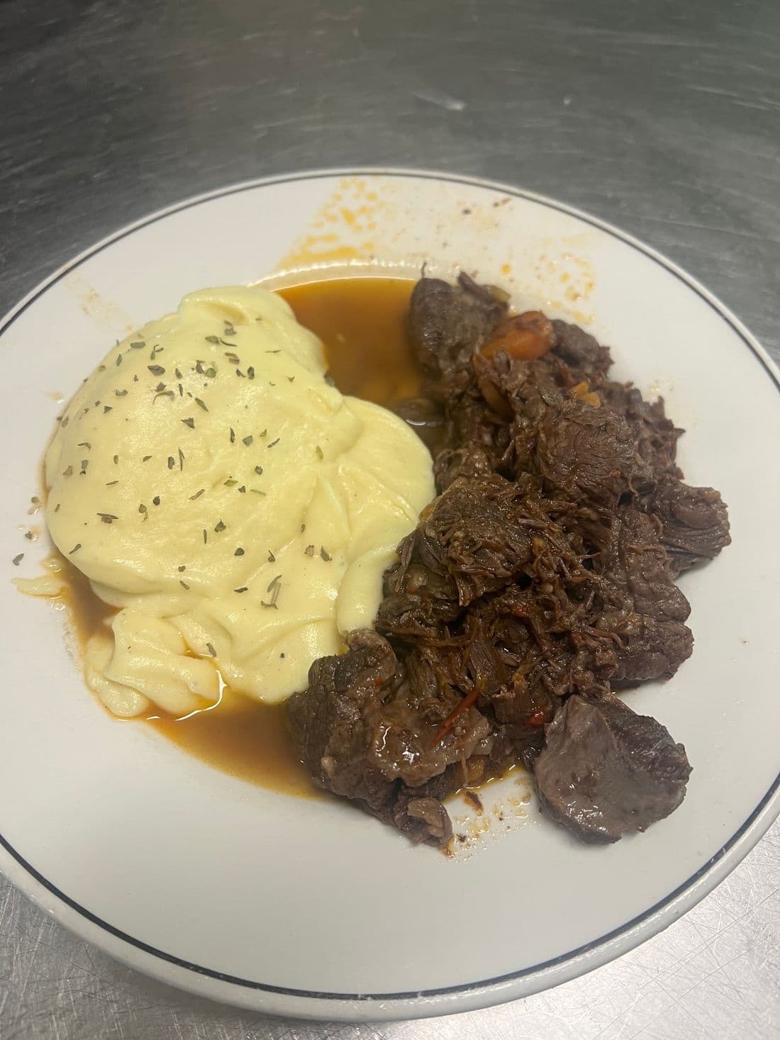 Carne guisada con su crema de patata al lado
