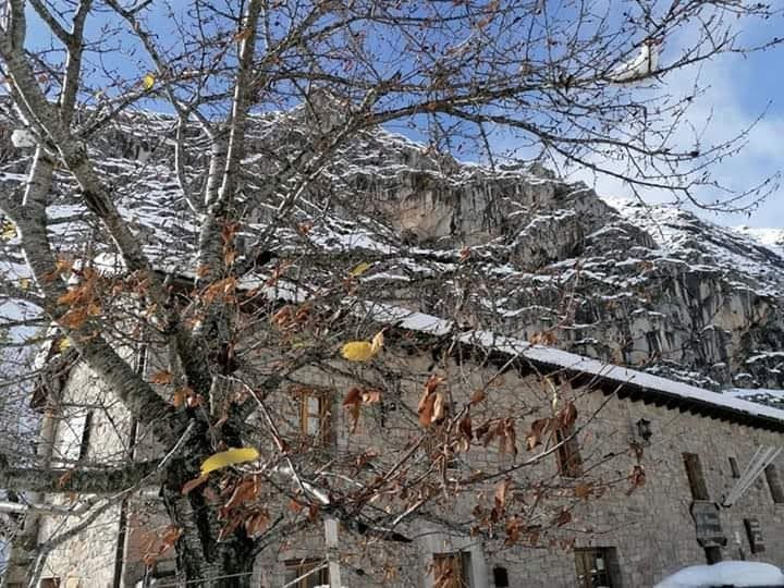 La venta y las casas de piedra del pueblo, con nieve en los tejados
