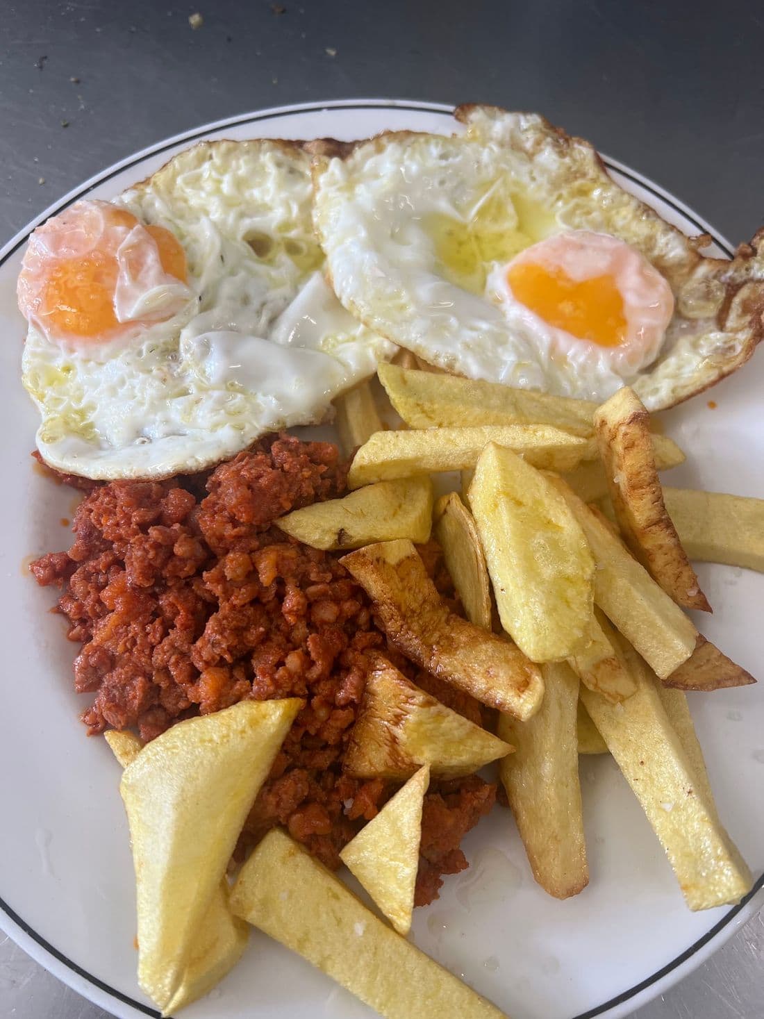Picadillo con dos huevos fritos y patatas